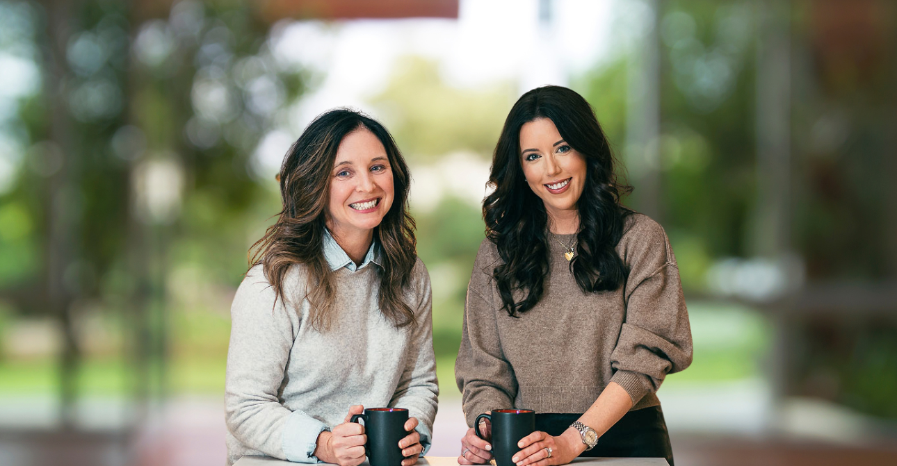 Mandy Caldwell and Kelley Swann, Co-Founders of GoodTalkCo, smiling and holding coffee mugs